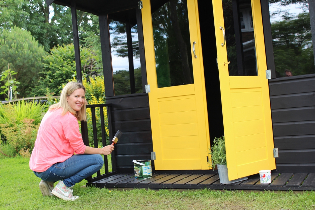 Painting a shed in a black ash deckstain with bright yellow exterior doors make a strong colour statement