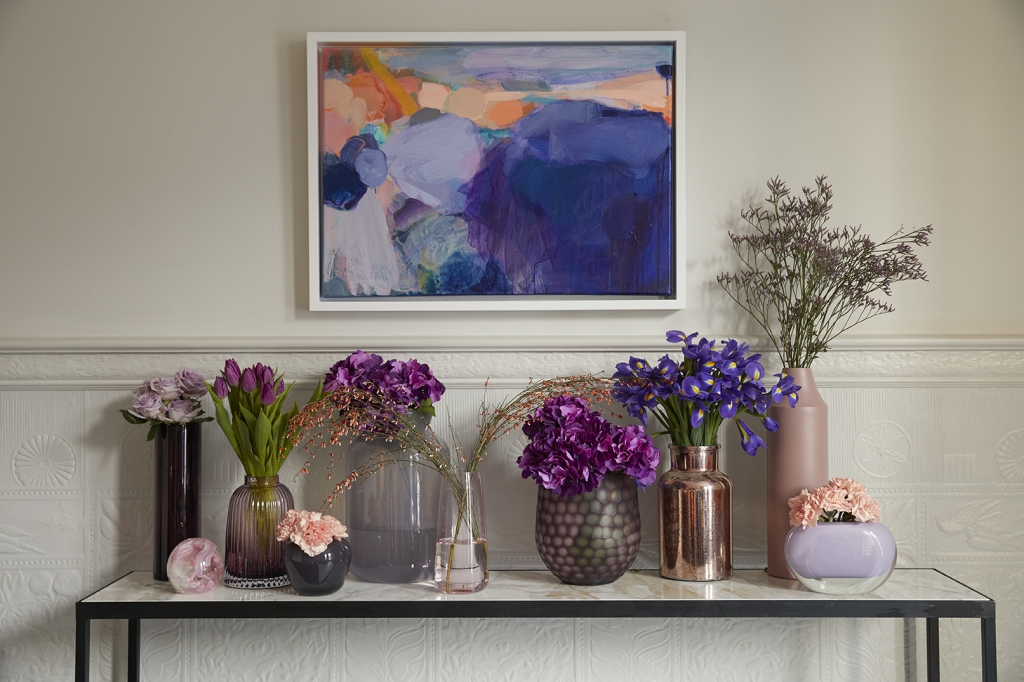 pantone colour of the year 2018 is ultra violet. a simple way to add purple to your interior design colour scheme is with purple flowers. a side board ciollection of vases with iris's, hydrangeas, and tulips is perfect. painting by sophie abbott