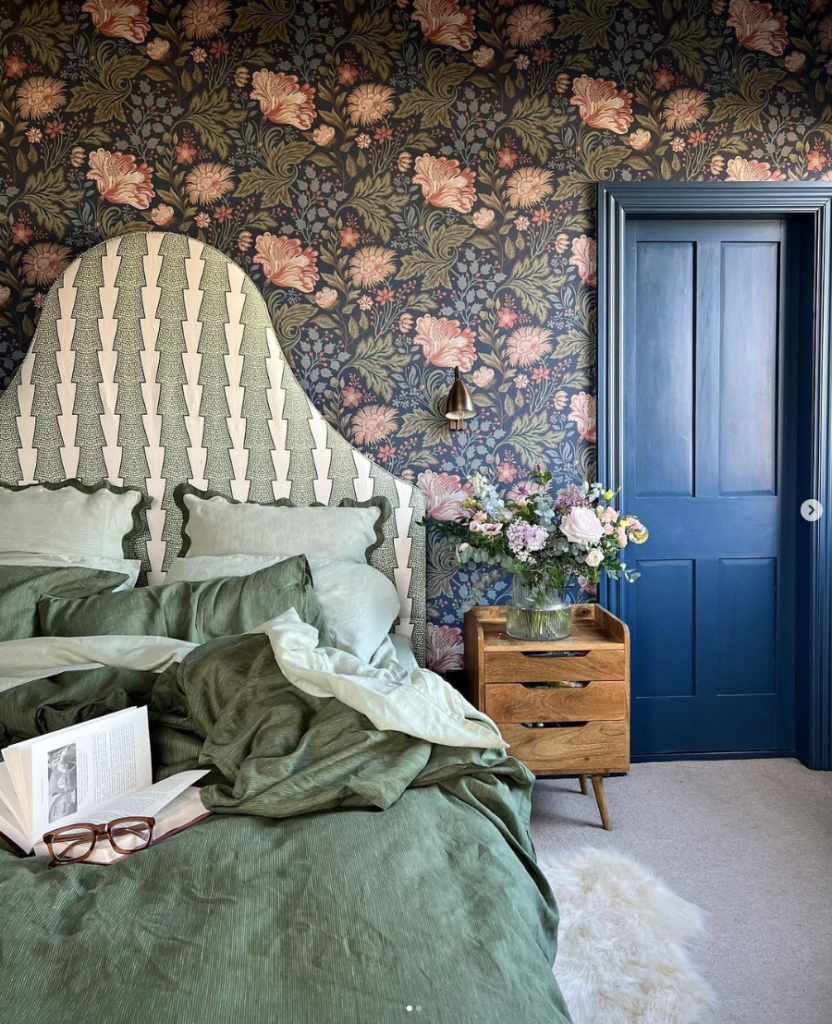 Maximalist Wallpaper and headboard in bedroom with blue door