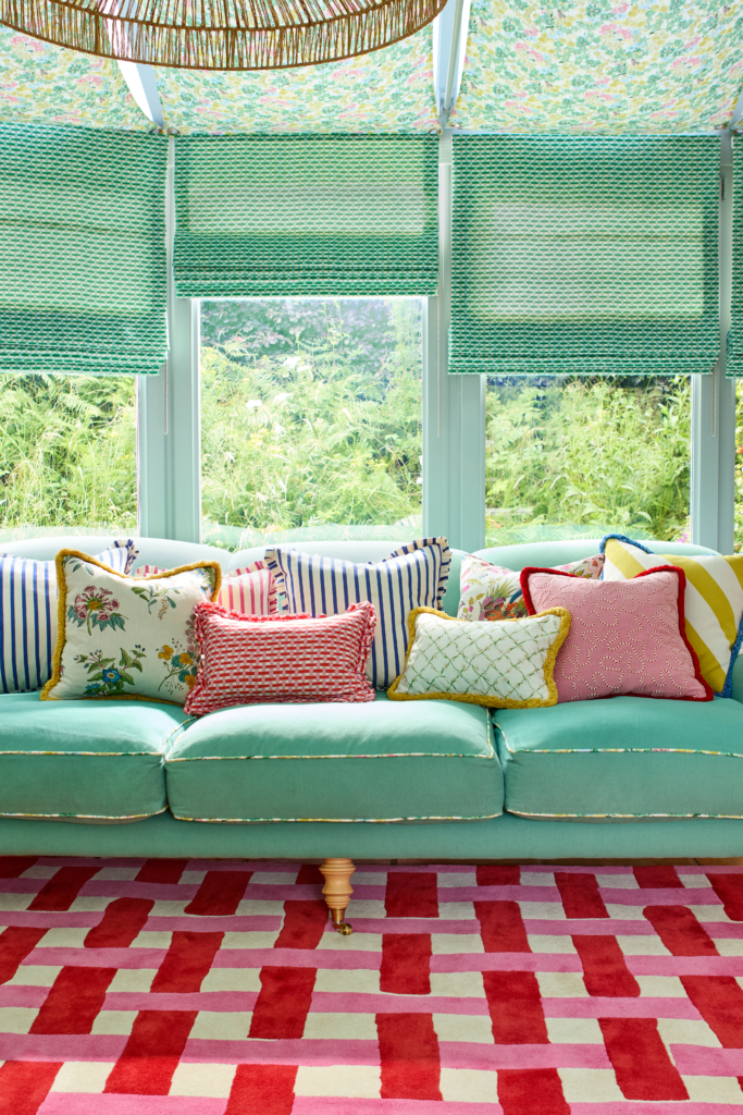 Basketweave red and pink rug with green sofa